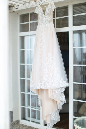 White bridal amazing dress hanging on hanger outdoors.の写真素材