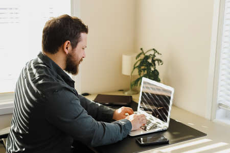 Male manager working in office, looking at laptop computer screen.の写真素材