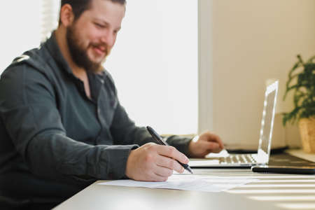 Office worker working with documents and using laptop.の写真素材