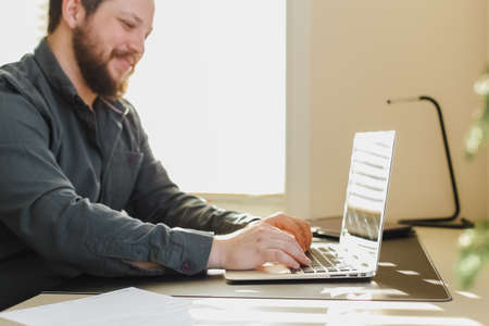 Male copywriter writing article on laptop at office.の写真素材