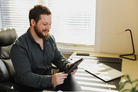View of a Young business man working at home on his tabletの写真素材