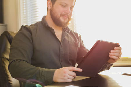 Sunshine portrait of finance director using tablet at cabinet.の写真素材