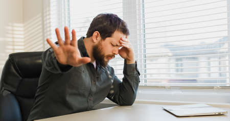 Thinking director asking to leave alone, closed laptop in desk.の写真素材