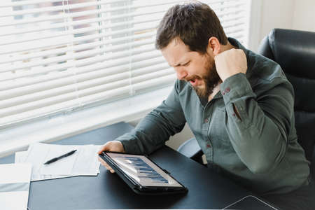 Serious male enterpreneur using digital tablet and working with documents.の写真素材