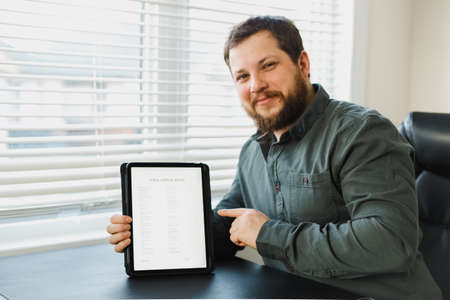 Man getting visa and reading application on tablet.の写真素材