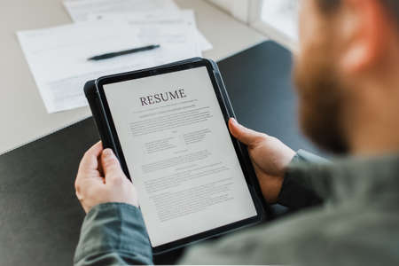 Male job seeker review electronic resume on tablet.の写真素材