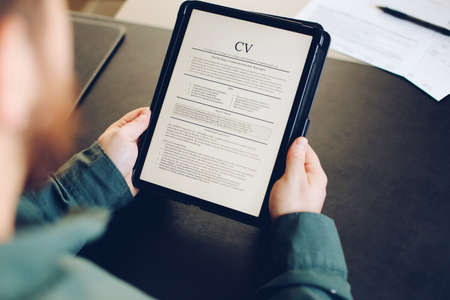 Male person review electronic cv on tablet.の写真素材