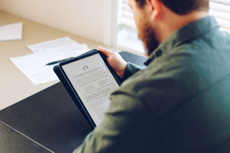 American businessman review electronic cv on tablet.の写真素材