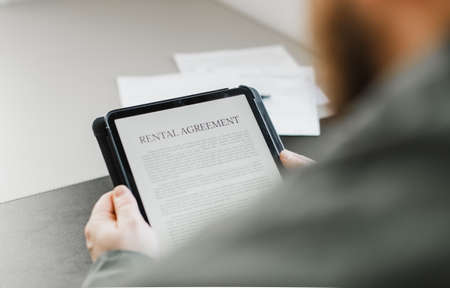 Close up businessman reading elecronic rental agreement on tablet.の写真素材