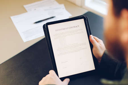 Businessman reading template investment contract on tablet.の写真素材