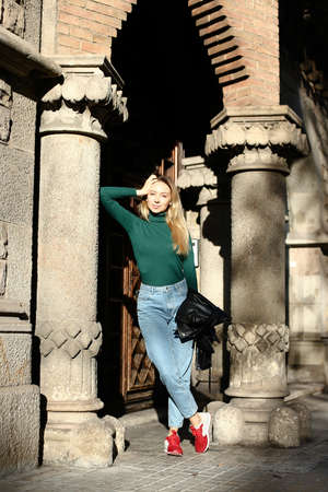Young female person leaning on column of medieval arch.の写真素材