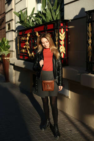 Young blonde girl standing near red balcony in city, Paris.の写真素材