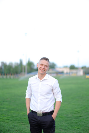 Young boy standing on football field and wearing white shirt.の写真素材
