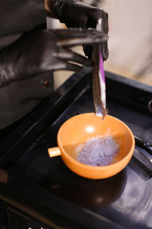 Professional female hairdresser preparing color to female customer at design hair salon, woman having her hair dyed, Hair dye colouring in processの写真素材