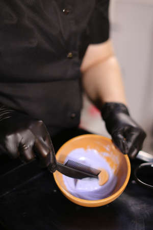 Professional female hairdresser preparing color to female customer at design hair salon, woman having her hair dyed, Hair dye colouring in processの写真素材