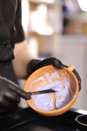 Professional female hairdresser preparing color to female customer at design hair salon, woman having her hair dyed, Hair dye colouring in processの写真素材