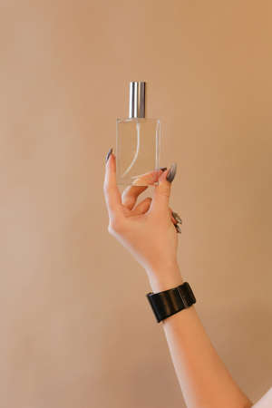 elegant sensual young woman holding perfume, golden tonesの写真素材