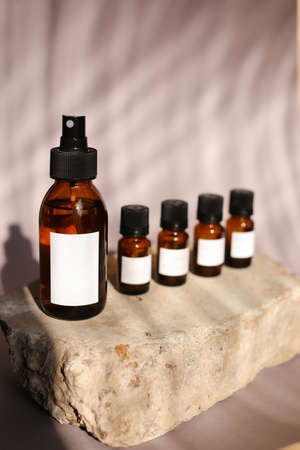 different cosmetics products on rock, Essential oils or face toner samplesの写真素材