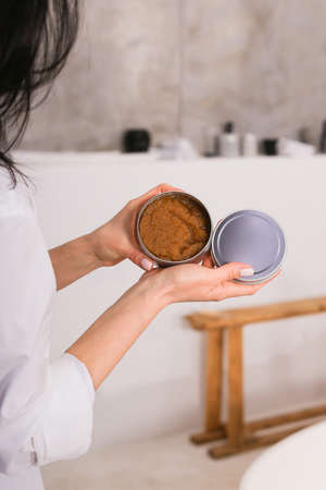 Woman holding botle or jar for spa cosmetics purpose in bathroom. Beauty blogger, salon therapy, minimalism concept, copyspaceの写真素材