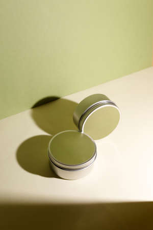 White cream in round aluminum metal tin on neutral background. Natural cosmetic product. Face and body skin care, cosmetic products.の写真素材