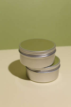 White cream in round aluminum metal tin on neutral background. Natural cosmetic product. Face and body skin care, cosmetic products.の写真素材