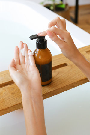 Womans holding botles with spa cosmetics in bathroom. Beauty blogger, salon therapy, minimalism...