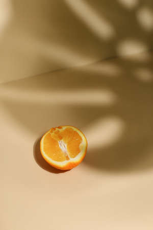 Slice of fresh orange isolated on beige backgroundの写真素材