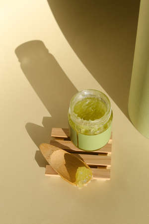 Cosmetic cream container with face or body cream on neutral background