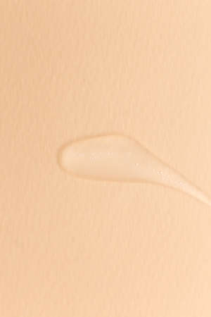 Cream gel transparent cosmetic sample texture isolated on beige backgroundの写真素材