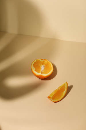 Slice of fresh orange isolated on beige backgroundの写真素材