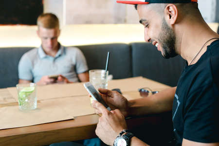 Male friends in cafe talk discuss with technology phone tabletの写真素材