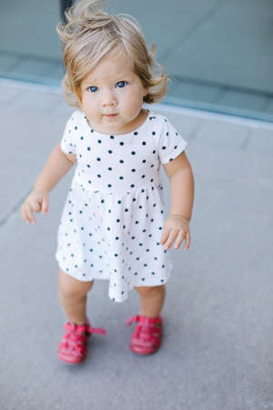A cute baby girl looking up at the camera. Vertical shot.