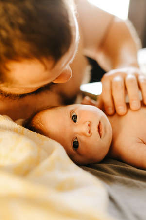 Close up portrait of man holding newborn baby.の写真素材