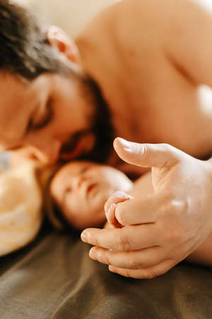 Close up focus on arms, portrait of father holding newborn baby.の写真素材