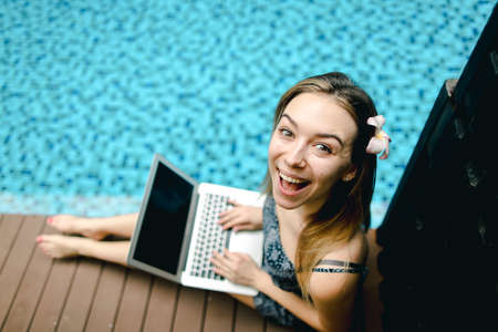 Close-up portrait of happy woman with laptop sunny on day on swiの写真素材