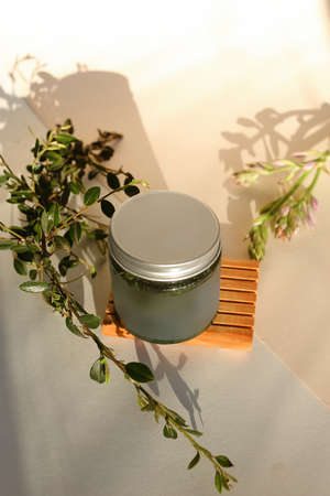 plastic jar with cream and lid isolated on neutral light background. Beauty spa and taking care of skin productの写真素材