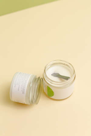 plastic jar with cream and lid isolated on neutral light background. Beauty spa and taking care of skin productの写真素材