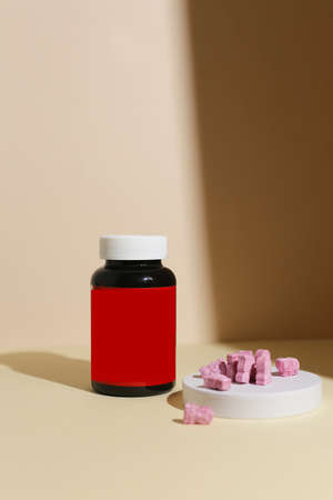 dietary supplements on neutral background Selective Focus on orange jelly tablet, blurred front and blurred backgroundの写真素材