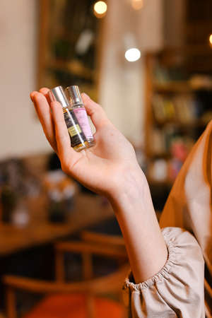 elegant sensual young woman holding perfume, golden tonesの写真素材