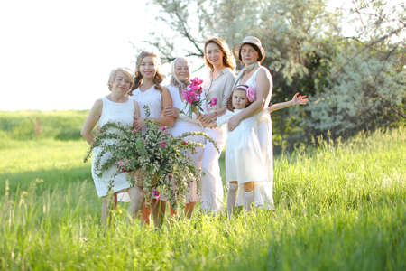 Caucasian happy granny standing with daughters, granddaughters and grand granddaughter outside.の写真素材