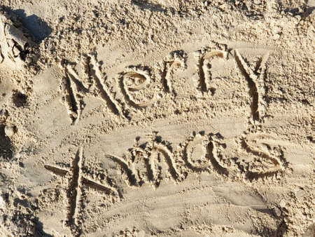 Hand written Merry Xmas greeting on Brown beach sandの写真素材