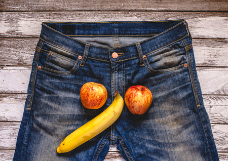 banana and apple out of mens jeans like mens penis. potency conceptの写真素材