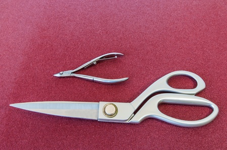 Skin and fabric cutting scissors on red background の写真素材