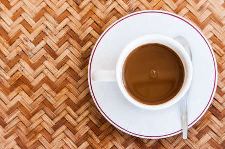 Coffee cup on the table with woven bamboo の写真素材
