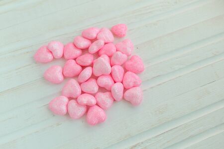Little pink hearts on a white wooden background. Valentine's Day. Wedding