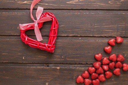 Red wicker hearts on a brown wooden background. Valentine's Day