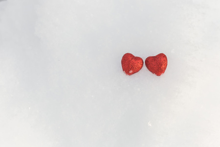 Little red shiny hearts in the snow