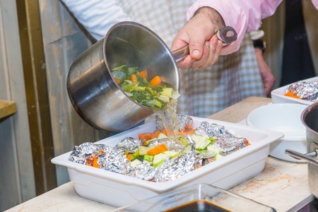 Man pours meat in foil broth