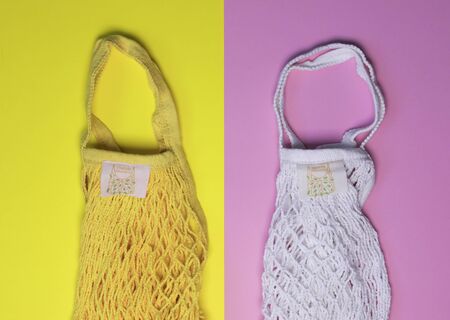 Reusable shopping bags white and yellow on pink yellow background. Zero waste concept. No plastic.