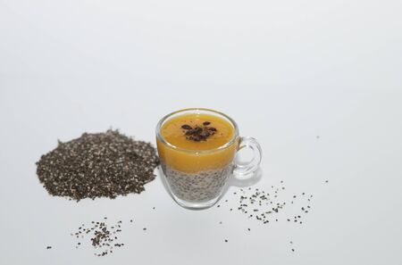 Healthy breakfast , Chia seeds pudding with fresh mango puree sprinkled with dark chocolate 97, almond milk on white background. Health care, fitness, diet, super food concept, raw vegetarian dessert. Copy space.の写真素材